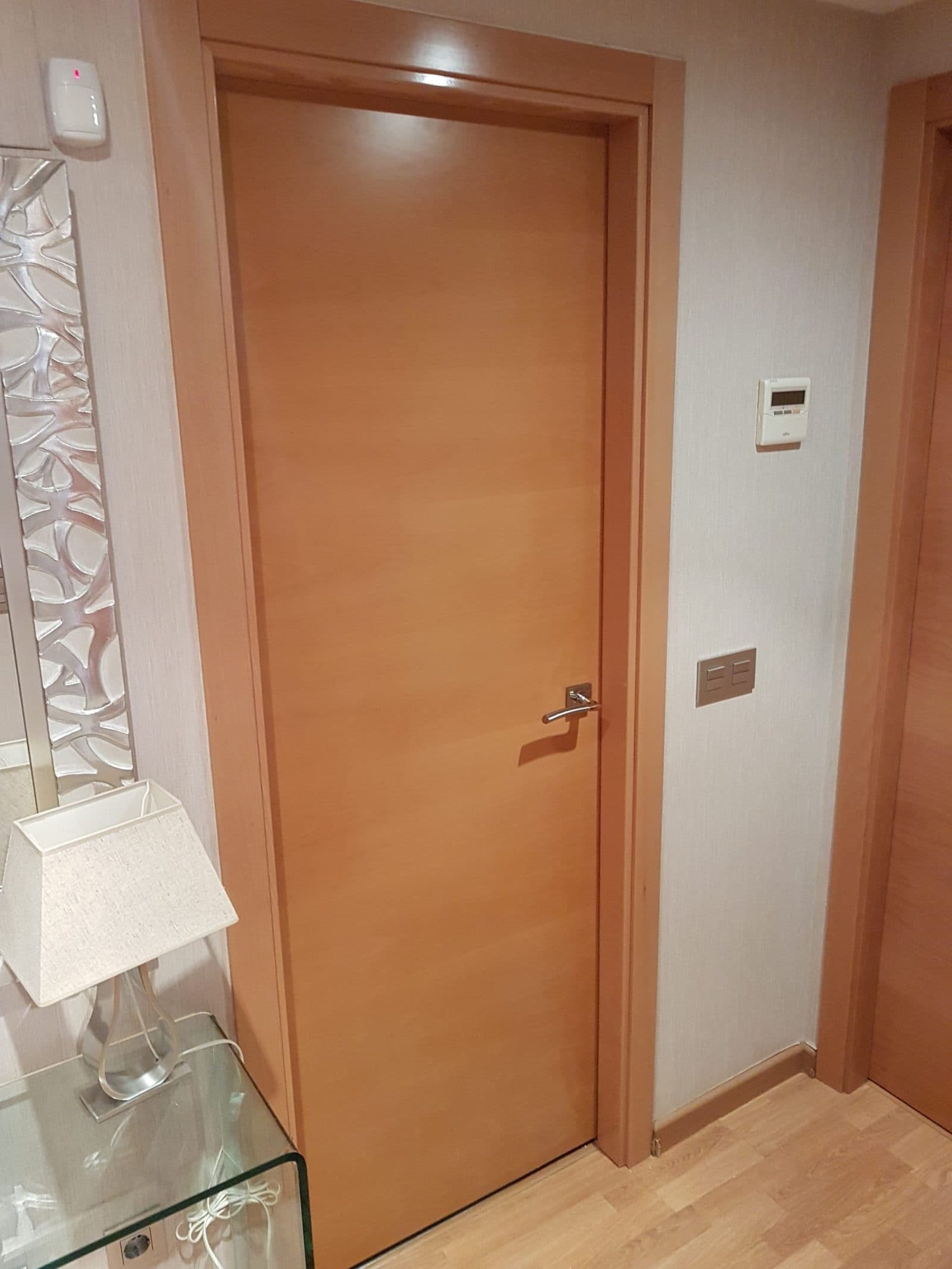 Puerta de paso de madera clara instalada en una vivienda