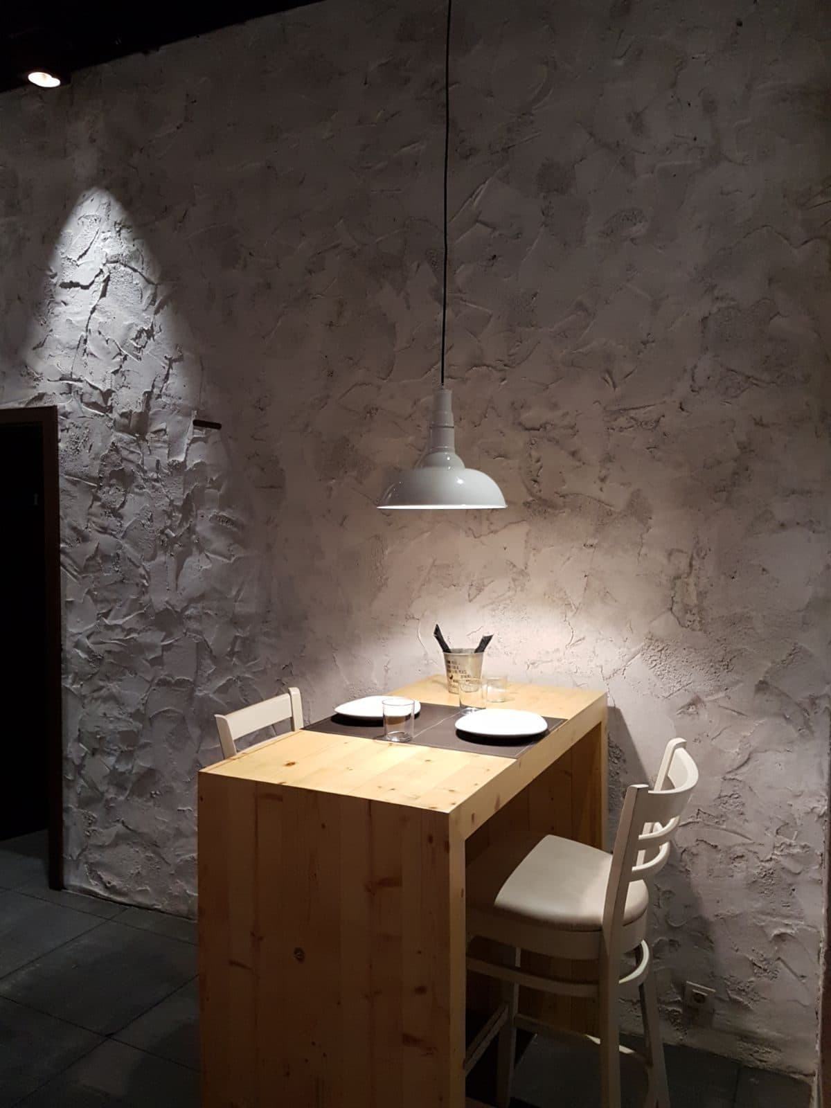 Mesa alta de madera maciza junto a una pared de piedra