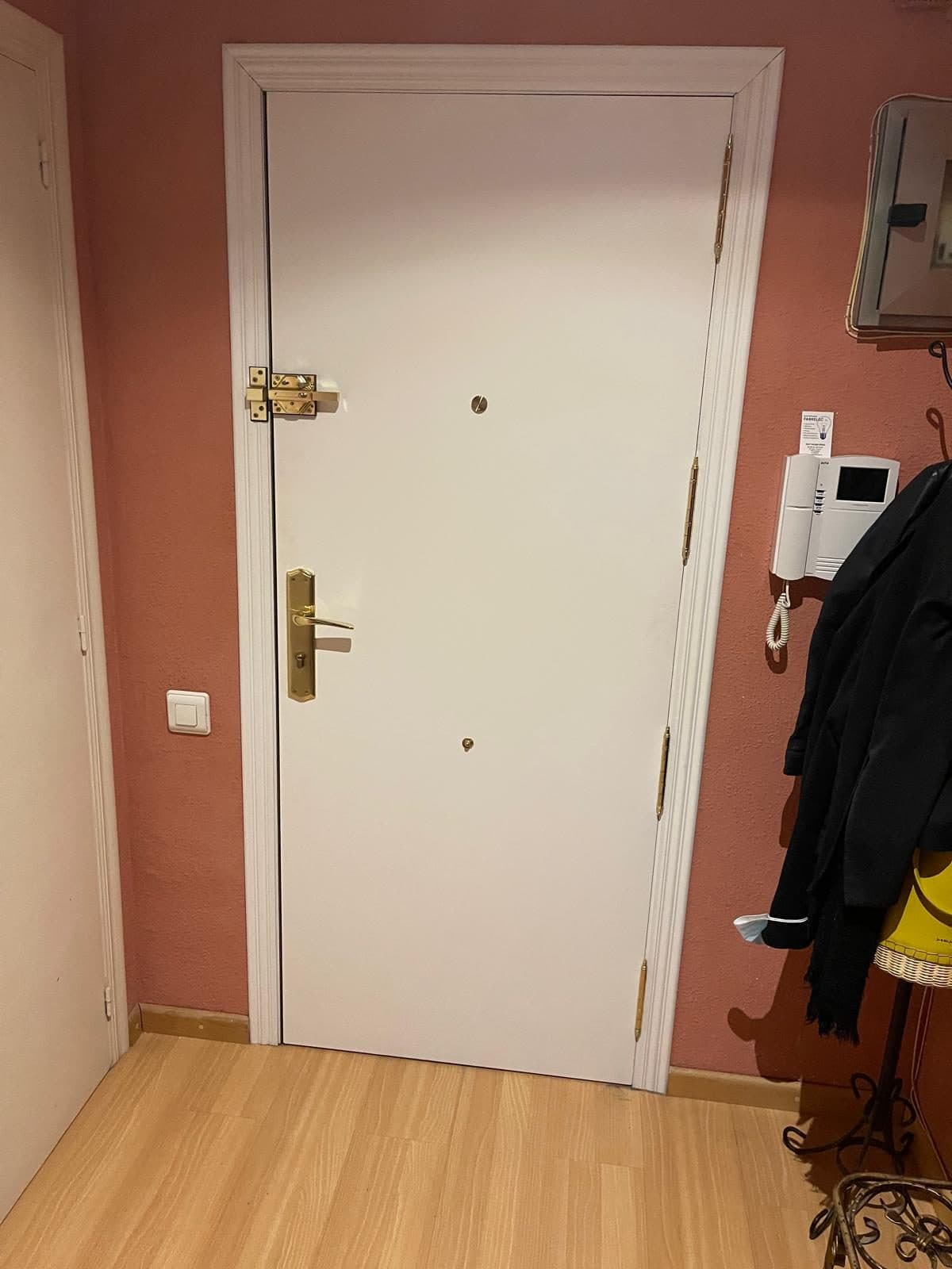 Puerta blindada lacada en blanco con herrajes dorados