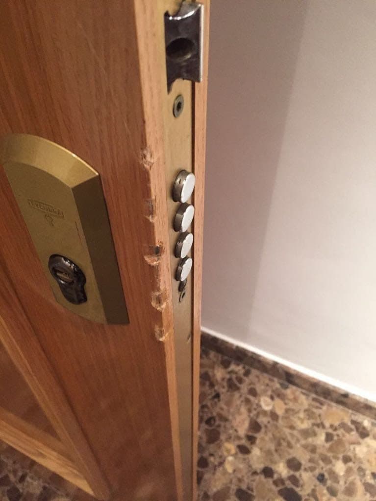Canto de una puerta con el escudo de seguridad y los bulones