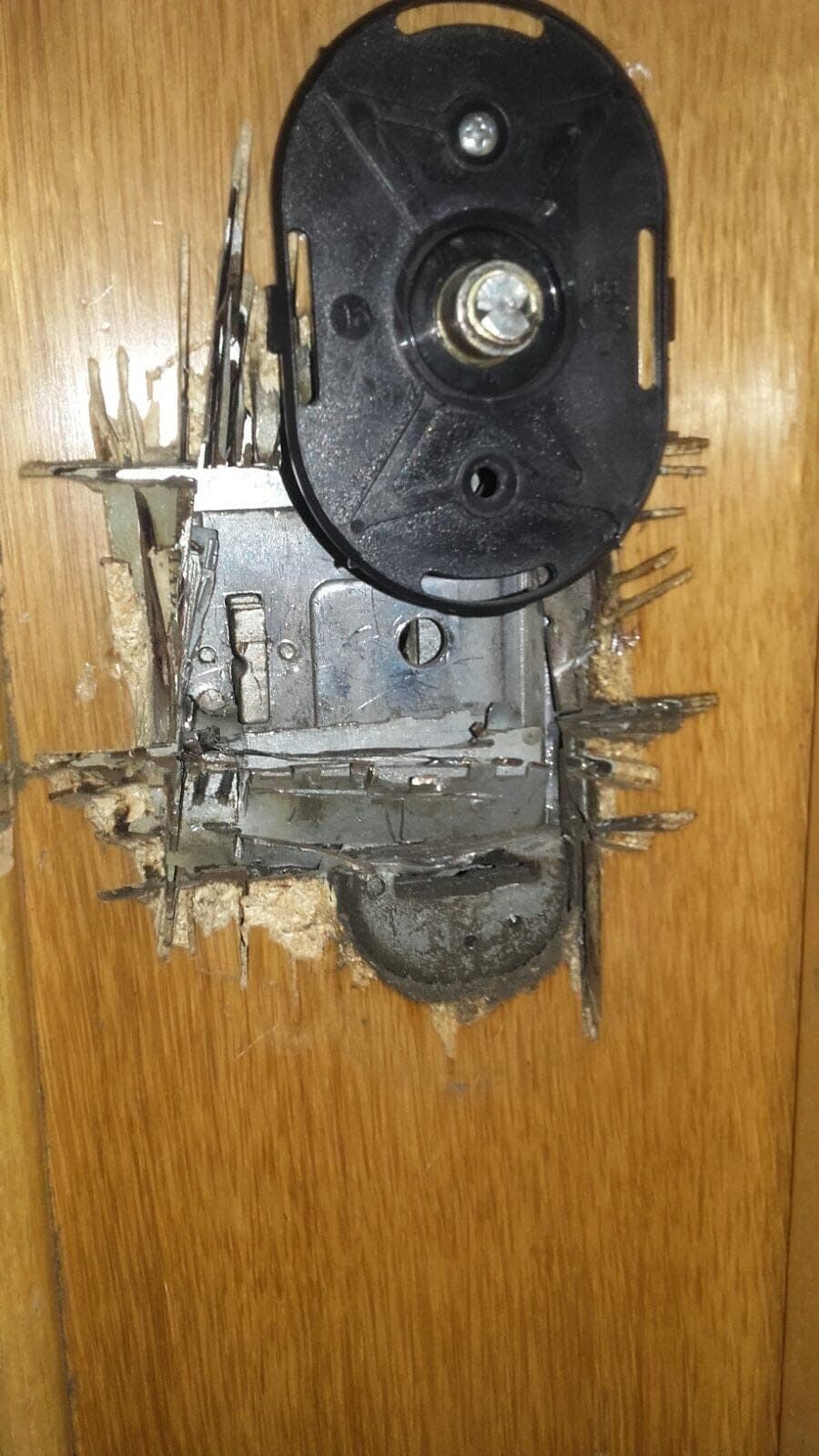 Cerradura arrancada de una puerta de madera después de un robo