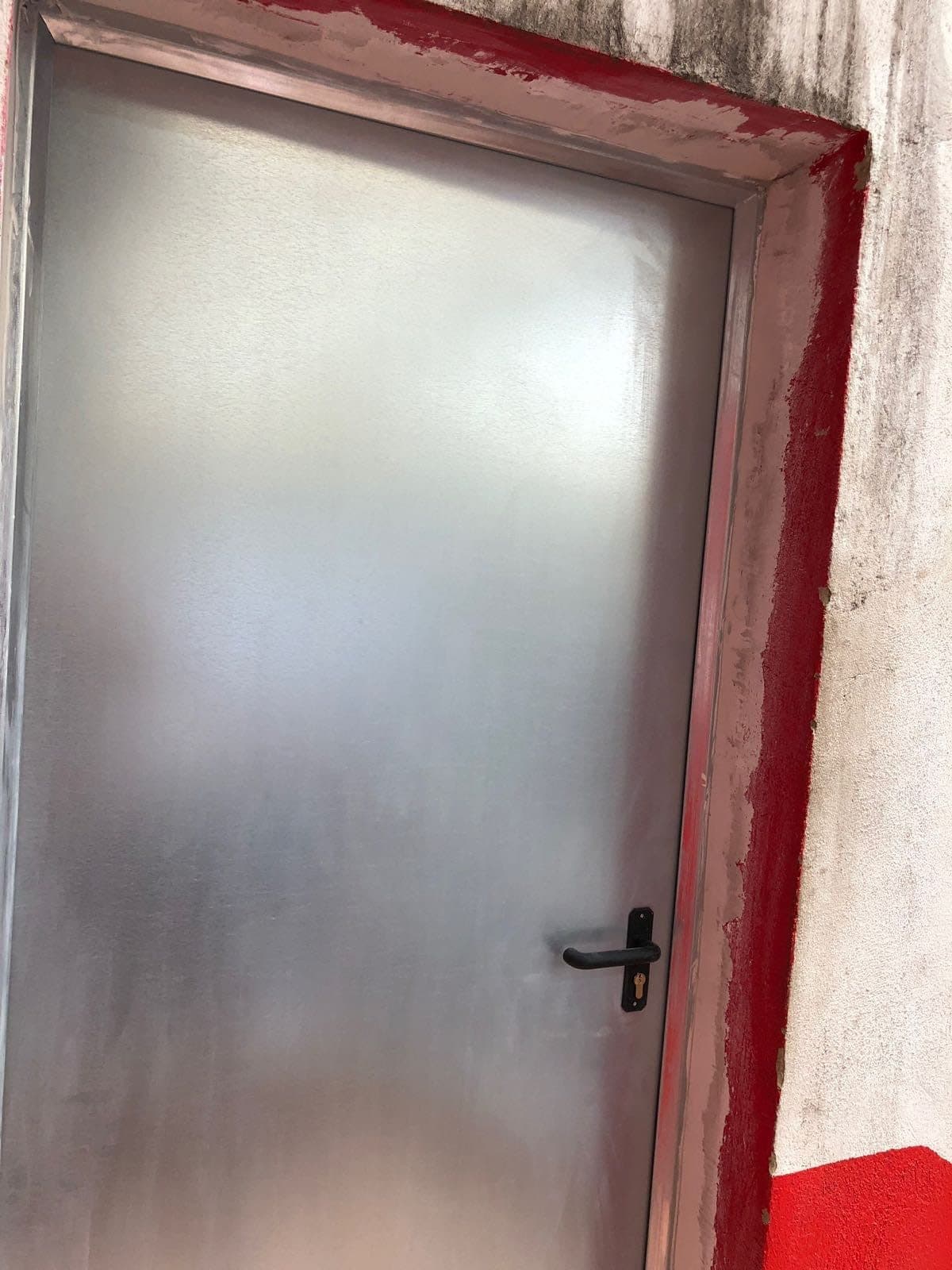 Puerta metálica nueva colocada en la entrada de un local