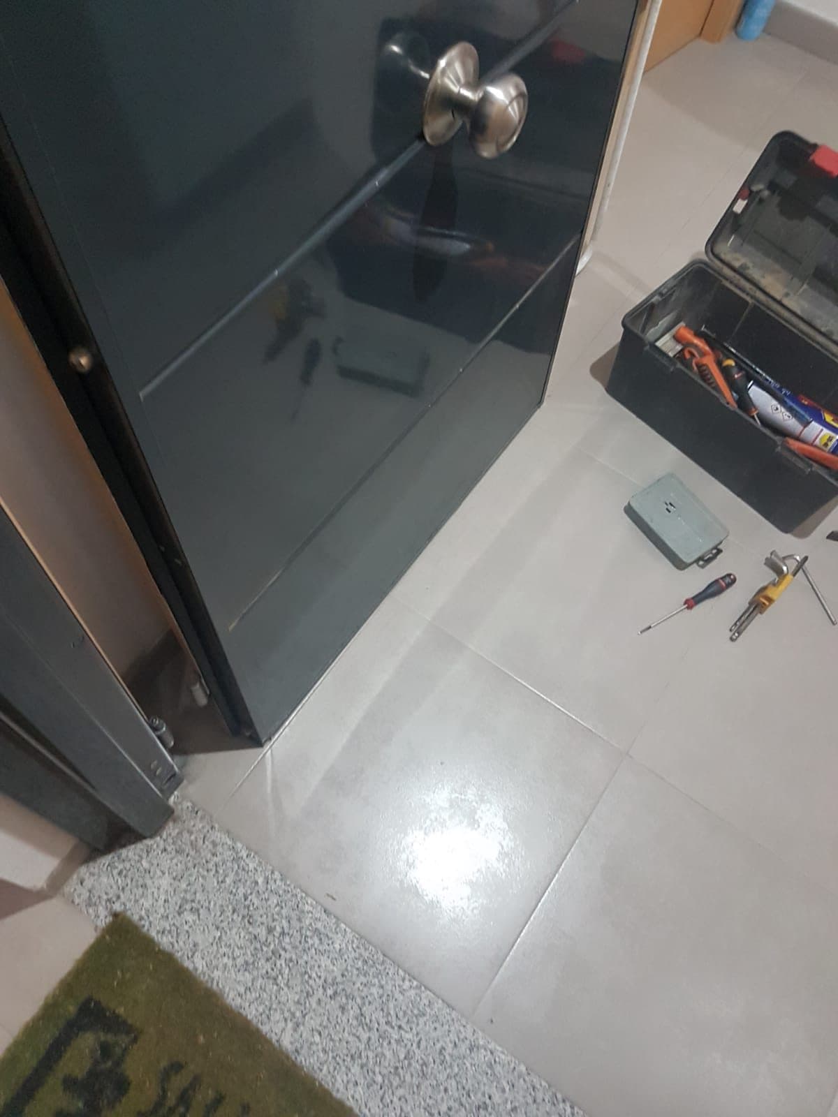 Puerta oscura durante la instalación, con las herramientas en el suelo