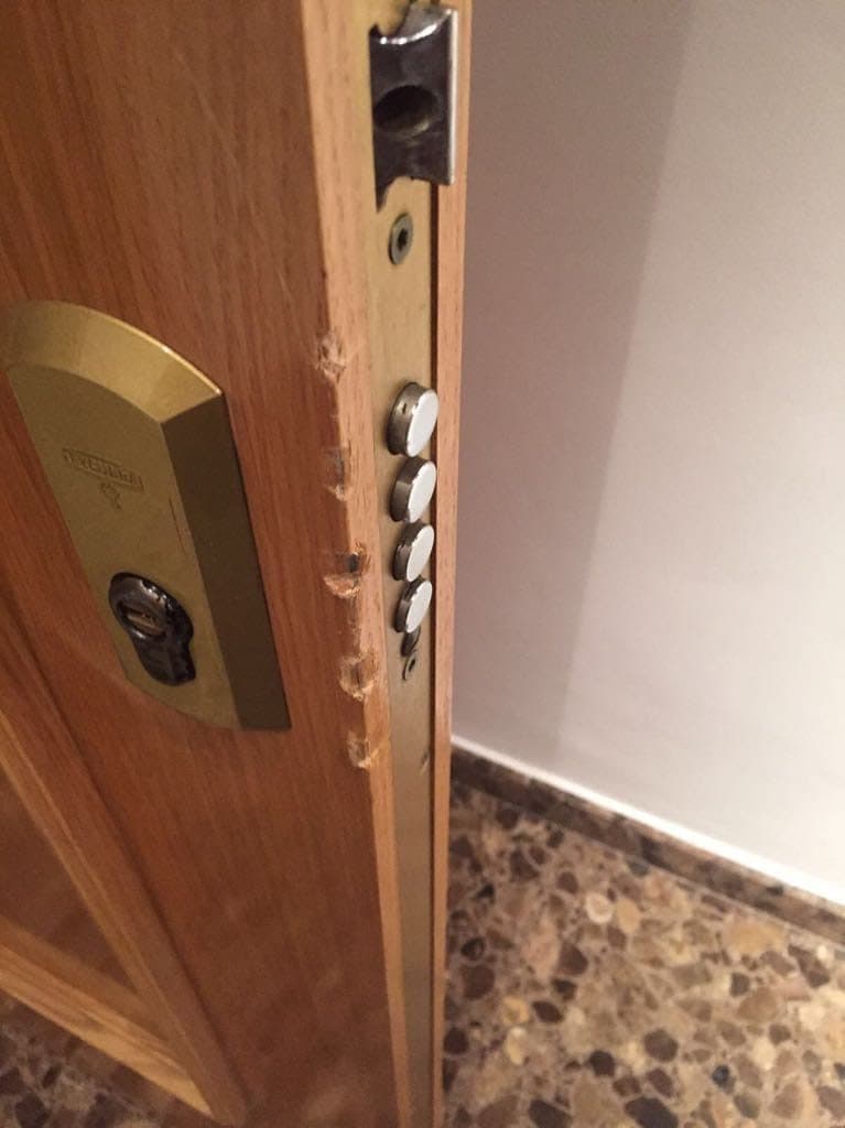 Canto de una puerta con el escudo de latón y los bulones de cierre